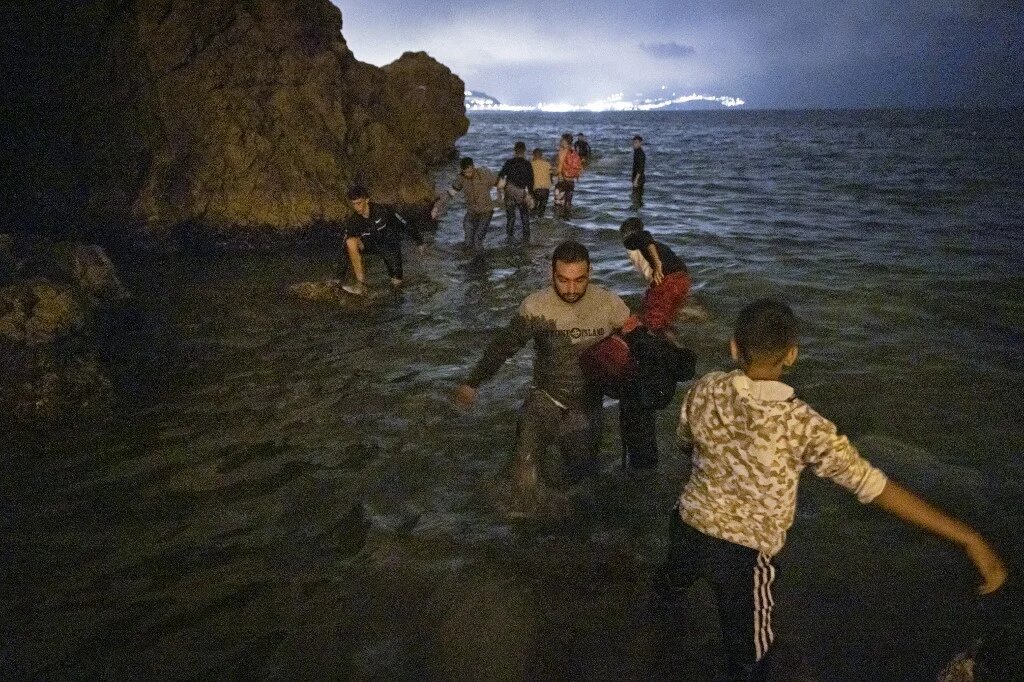 Des migrants marocains tentent de traverser la frontière entre le Maroc et l’enclave nord-africaine espagnole de Ceuta, le 18 mai 2021 (AFP)