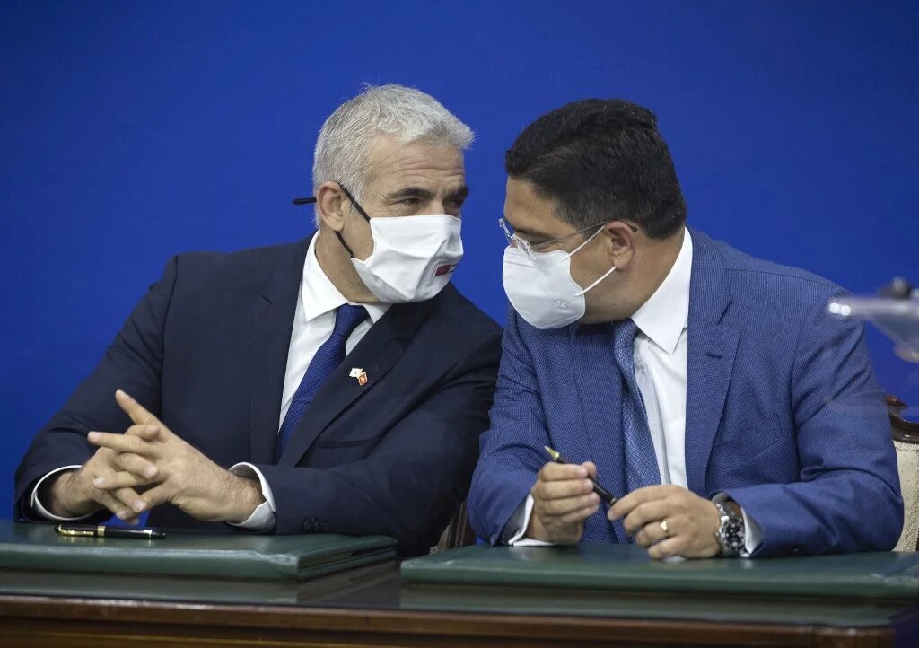 Yaïr Lapid et Nasser Bourita lors de la signatures de documents, le 11 août 2021 à Rabat (AFP/Fadel Senna)