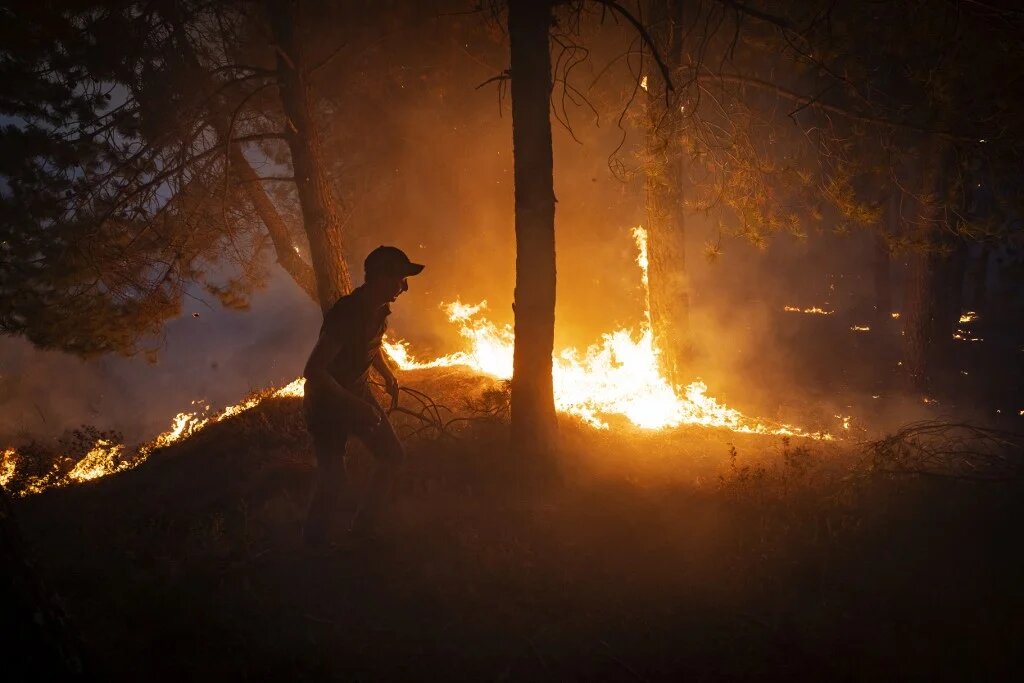 Un Marocain tente d’aider à éteindre le feu dans la région de Chefchaouen, dans le nord du Maroc, le 15 août 2021 (AFP/Fadel Senna) 