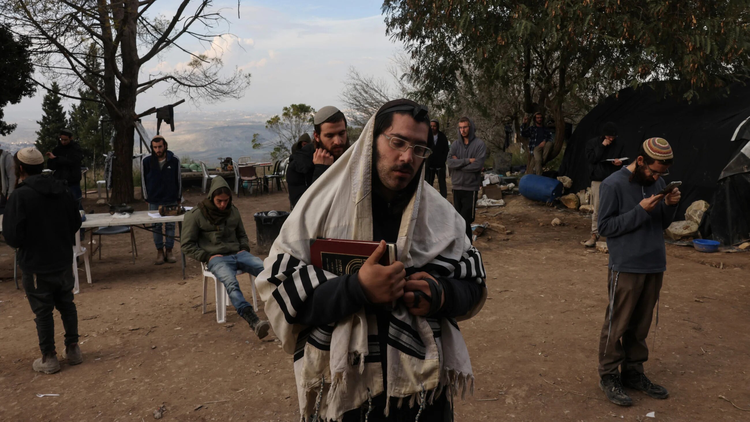 Israeli settlers pray in the former settlement of Homesh near the occupied West Bank city of Nablus, on 30 December 2021 (AFP)