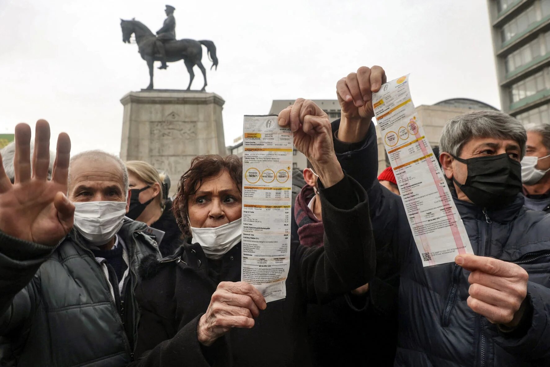 People hold up their electricity bills as they protest against high energy prices in Ankara on February 9, 2022, as temperatures plunged well below freezing and energy prices soared (AFP)