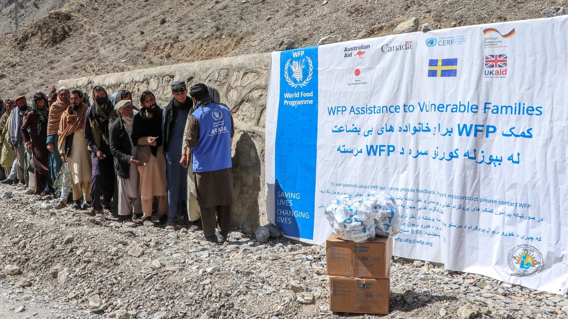 Afghan men queue to receive packages of fortified biscuits distributed by the United Nations World Food Programme (WFP) organisation in the Laja Mangal district of Paktia province.