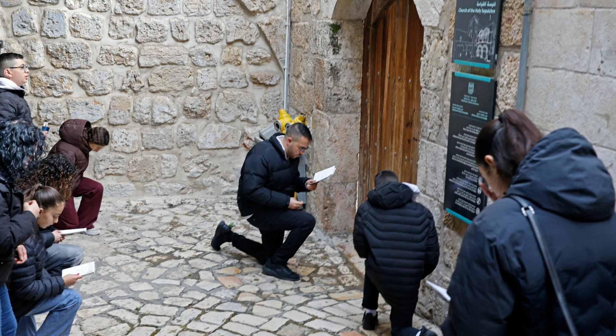 Christian pilgrims pray in front of the closed door of Church of the Holy Sepulchre in the Old City of Jerusalem on 3 April 2026 (Marco Longari/AFP)