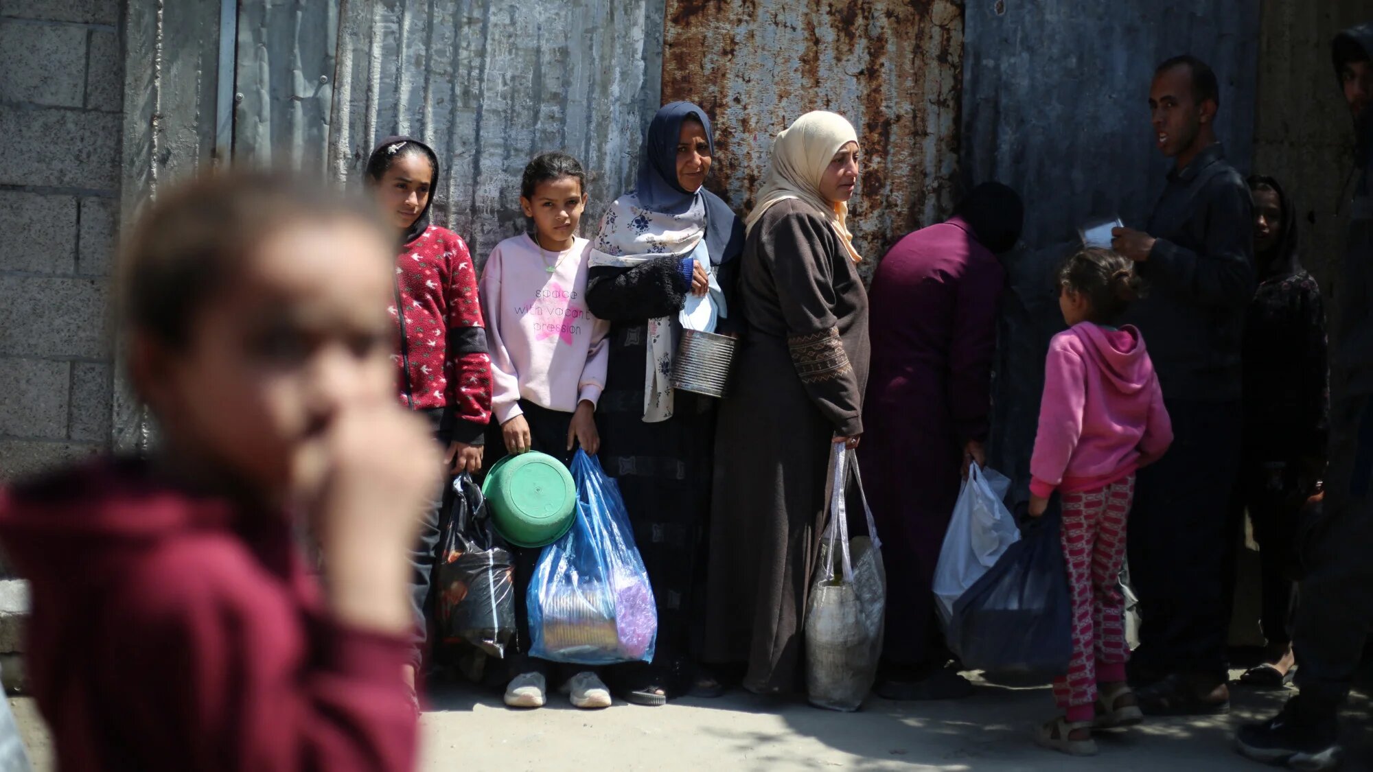 Displaced Palestinians wait to receive food from a charity kitchen at the Nuseirat refugee camp in the central Gaza Strip on 13 April 2026 (AFP/Eyad Baba)