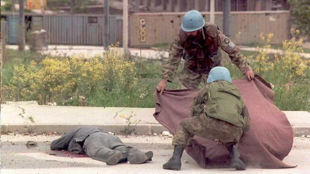UN peacekeepers recover the body of a civilian killed by sniper fire in the Sarajevo neighbourhood of Hrasno on 13 May 1995, during the city's siege by Bosnian Serb forces (AFP)
