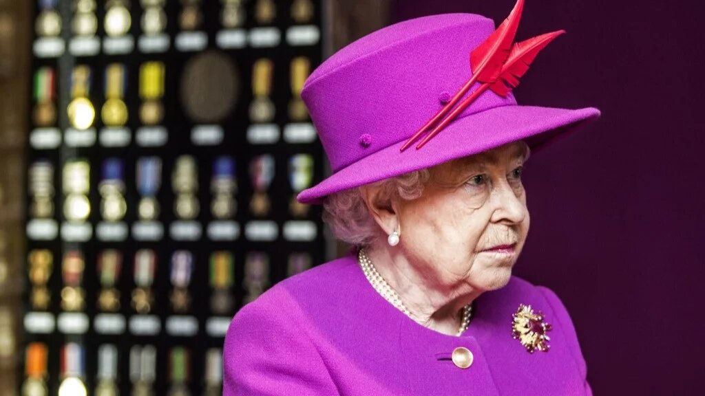 Queen Elizabeth II looks at a cabinet of medals issued during Queen Victoria's reign at the MOD Medal Office in the MOD’s Defence Business Services facility at Imjin Barracks in Gloucestershire, south west England, on November 5, 2015 (AFP)