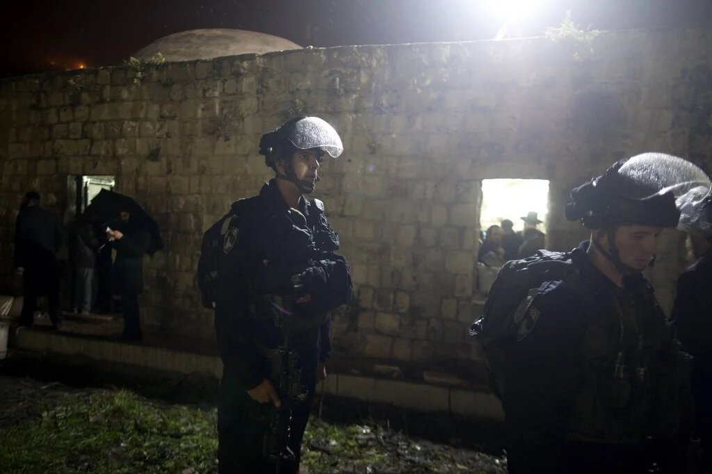 Israeli forces stand guard while Jews pray at Joseph's Tomb in the northern Palestinian West Bank city of Nablus on 16 February 2012. (AFP)