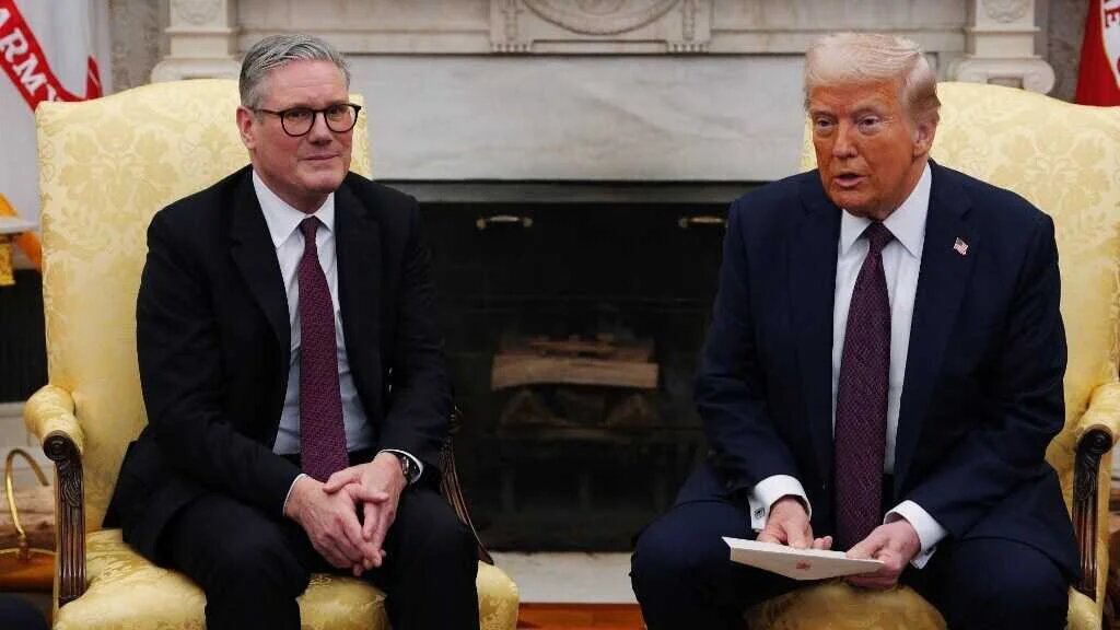 UK Prime Minister Sir Keir Starmer hands an invitation from King Charles III for a second state visit to U.S. President Donald Trump at the White House on February 27, 2025
