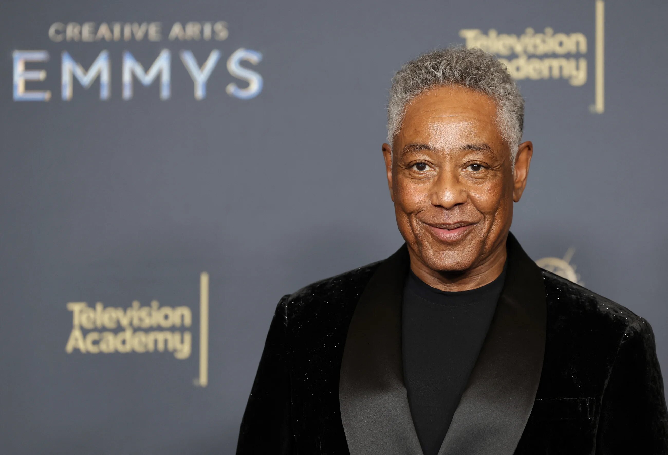 Giancarlo Esposito wearing a black tuxedo and posing for photographs at the 2025 Emmy Awards