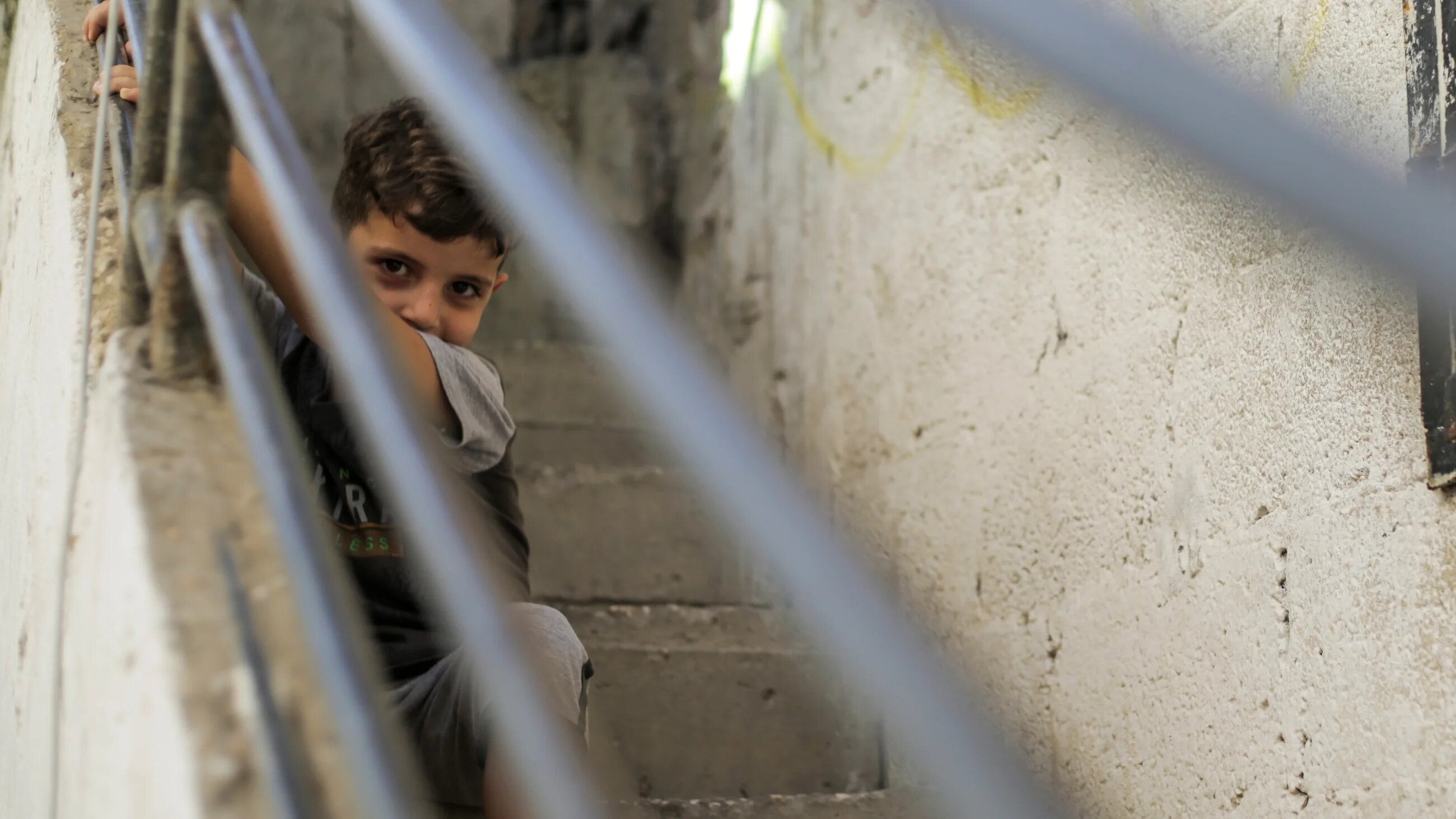 A Palestinian refugee boy sits outside his family home in the streets of Jabalia camp in the northern Gaza Strip (Reuters)