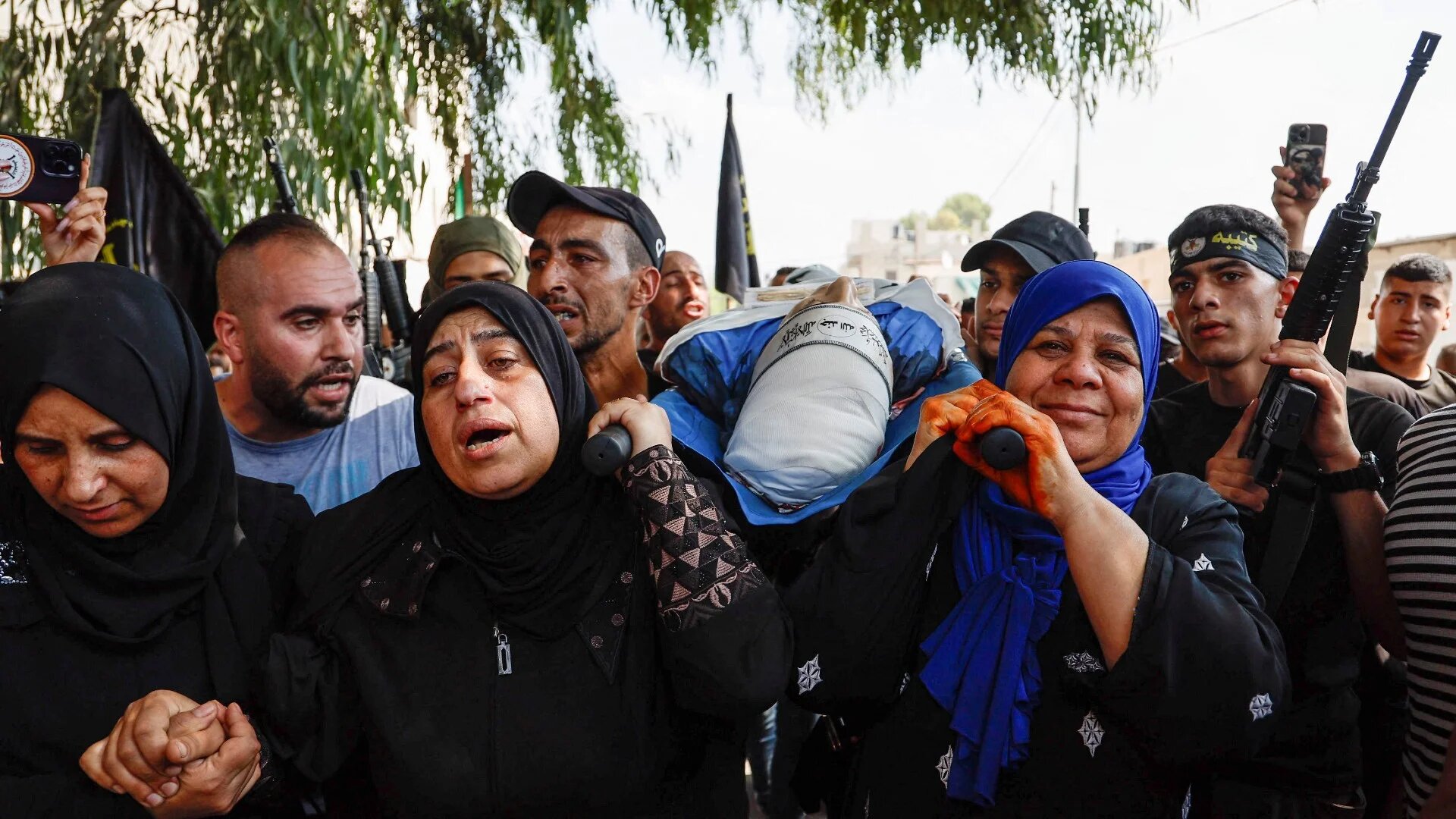 Mourners carry the body of a Palestinian fighter during his funeral in Jenin refugee camp, in the Israeli-occupied West Bank on 8 October (Reuters)
