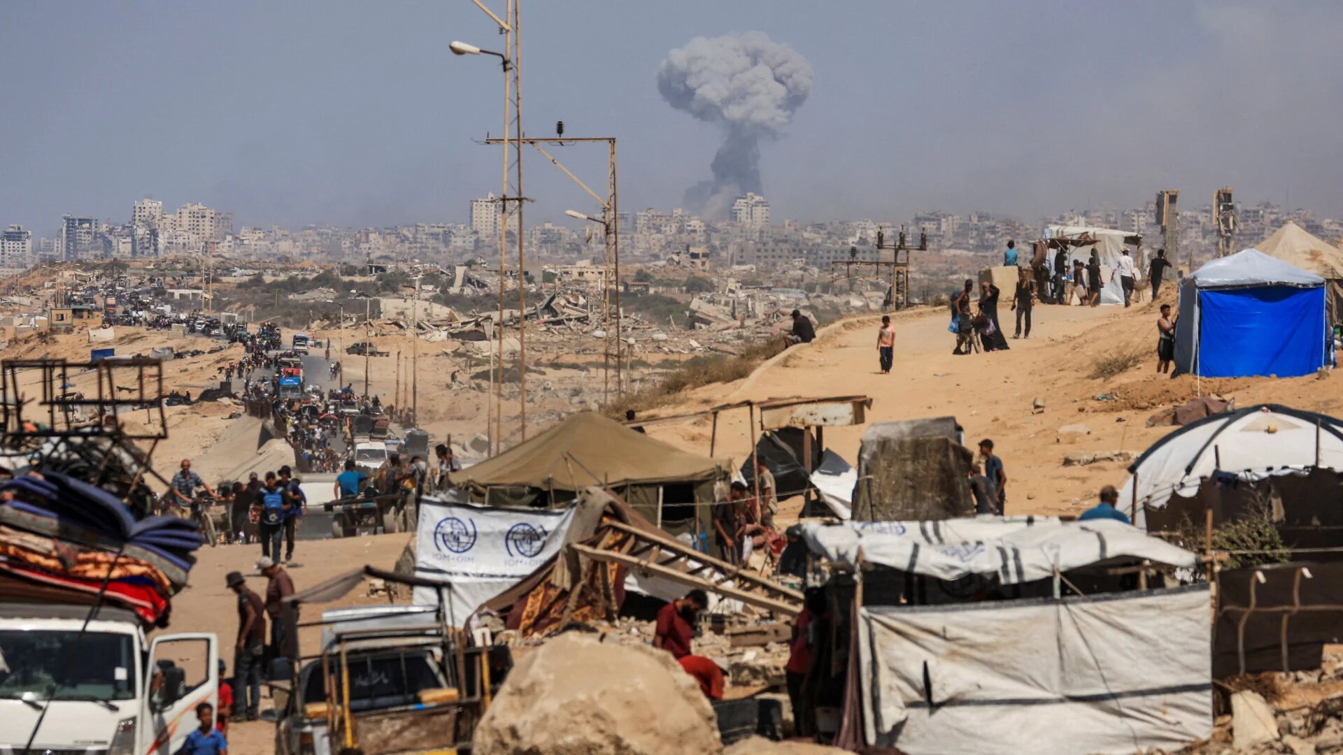 Smoke rises from an Israeli strike as Palestinians, forced to flee northern Gaza under Israeli evacuation orders, move south in the central Gaza Strip, on 22 September 2025 (Dawoud Abu Alkas/Reuters)