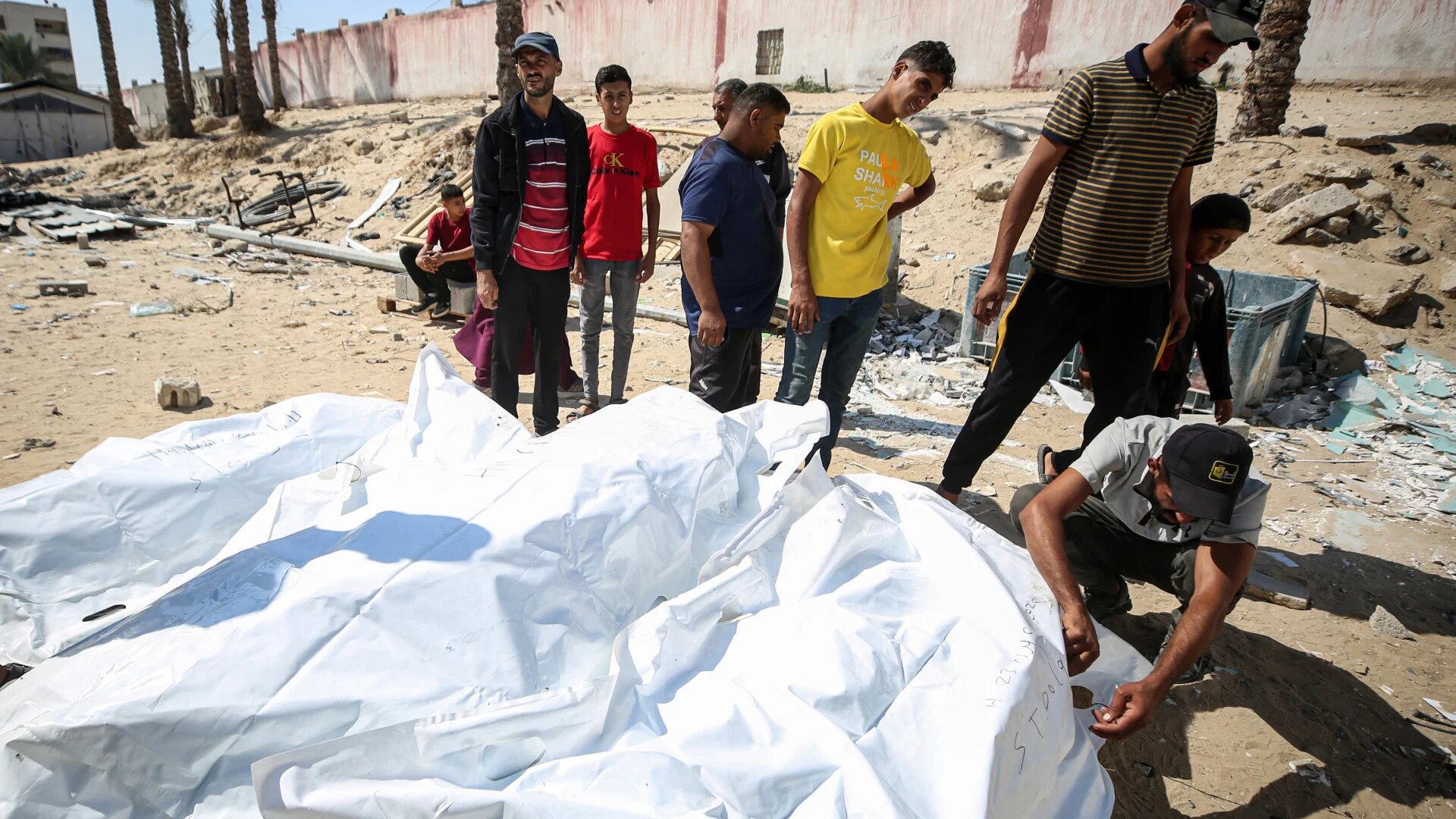 Morgue workers unload the bodies of Palestinians killed while in Israeli custody, returned under the US-brokered ceasefire deal, at Nasser Hospital in Khan Yunis, Gaza Strip, 15 October 2025 (Majdi Fathi/NurPhoto via Reuters)