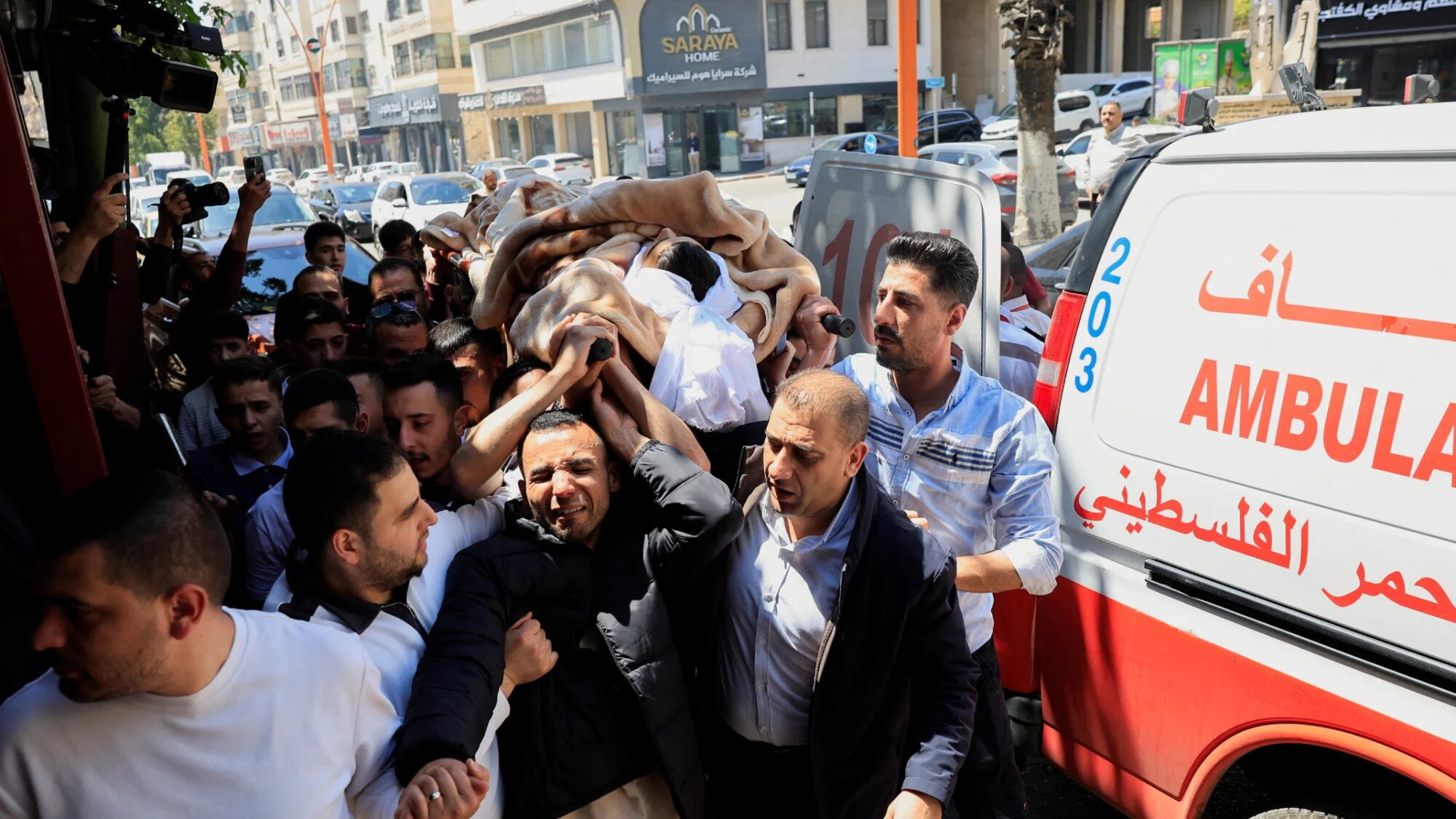 Mourners carry the body of 16-year-old Palestinian Ibraheem Khayyat, who was killed in an Israeli raid, during his funeral in Hebron, on 30 April 2026 (Mussa Qawasma/Reuters)