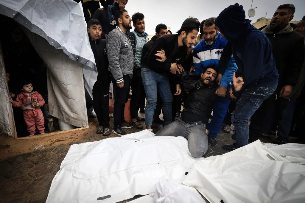 A man mourns relatives killed in an Israeli strike on the Maghazi refugee camp in the central Gaza Strip, 25 December 2023 (Mahmud Hams/AFP)