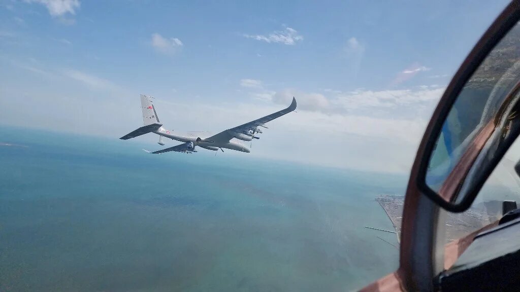 A Baykar Akinci combat drone seen from an Azerbaijani air force Mikoyan MiG-29 as it flies over Baku in May 2022 (Handout/Baykar Defence/AFP)