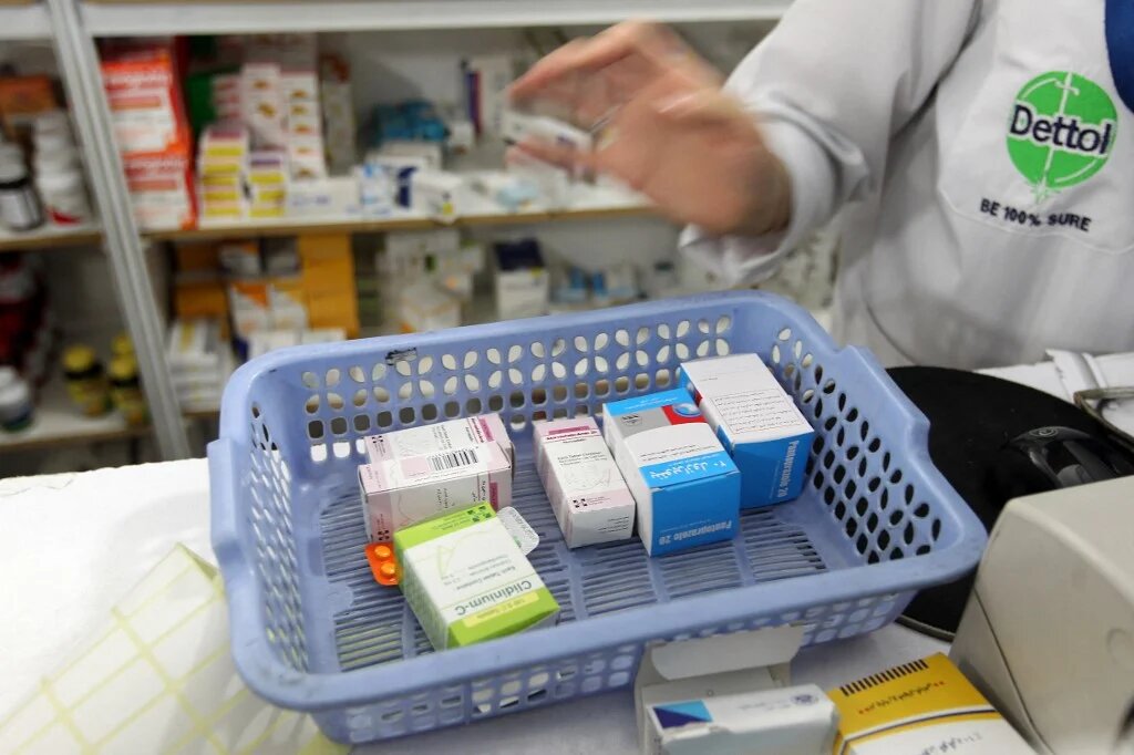 A pharmacist counts items bought by a customer in Tehran (File photo/AFP)