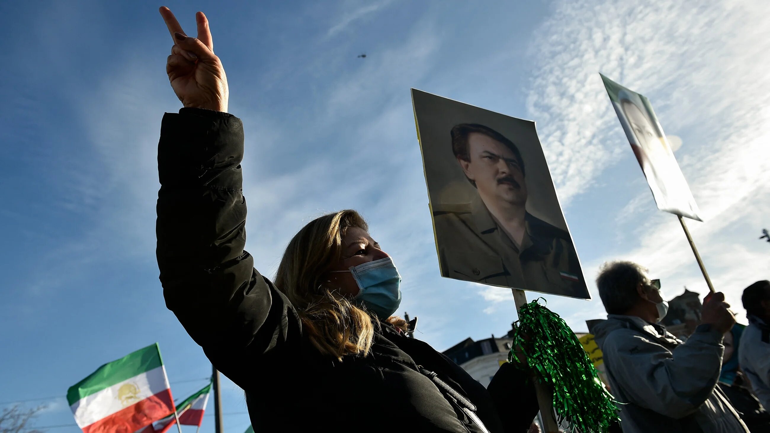 A woman protests outside the the Antwerp courthouse on 4 February, 2021, during the trial of four suspects including an Iranian diplomat accused of taking part in a plot to bomb an opposition rally in France (AFP)