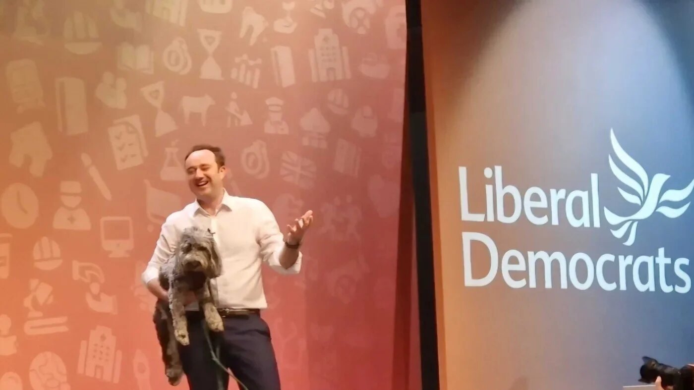 Lib Dem MP Danny Chambers came on to the stage to 'Who Let the Dogs Out', carrying a dog, at the party's conference on Saturday (MEE/Imran Mulla)