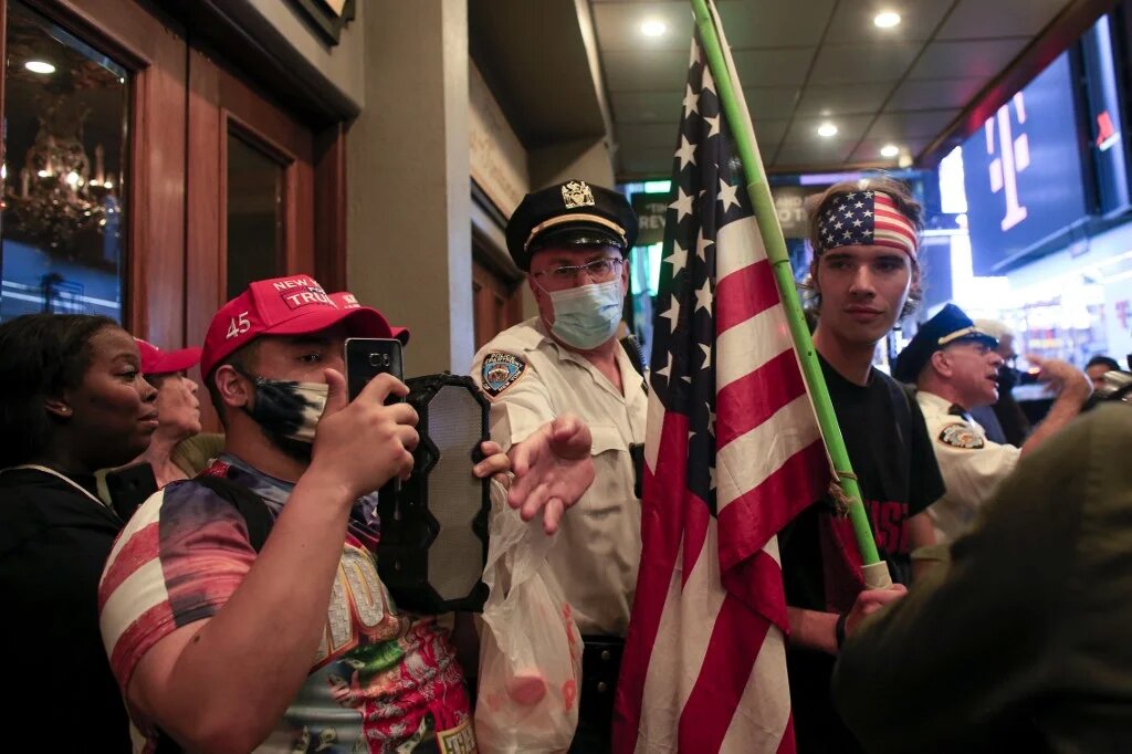 Police officers keep those affiliated with white supremacists separate from demonstrators attending a protest for Daniel Prude