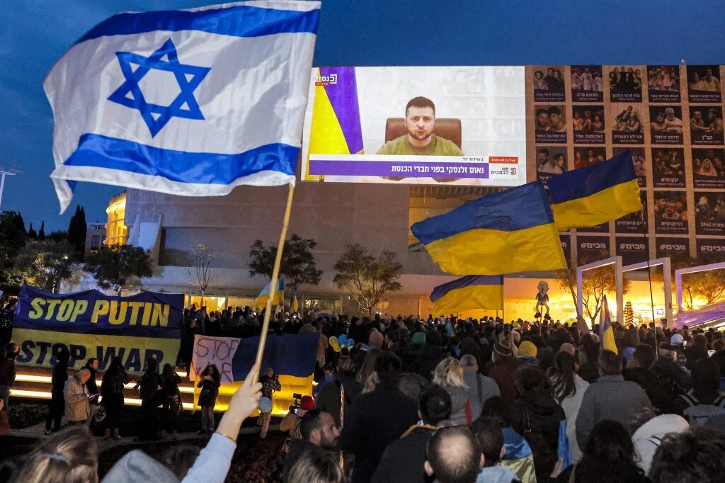 Demonstrators gather at Habima Square in the centre of Tel Aviv on 20 March 2022 to watch a televised video address by Ukraine's President Volodymyr Zelensky to the Israeli Knesset (AFP)