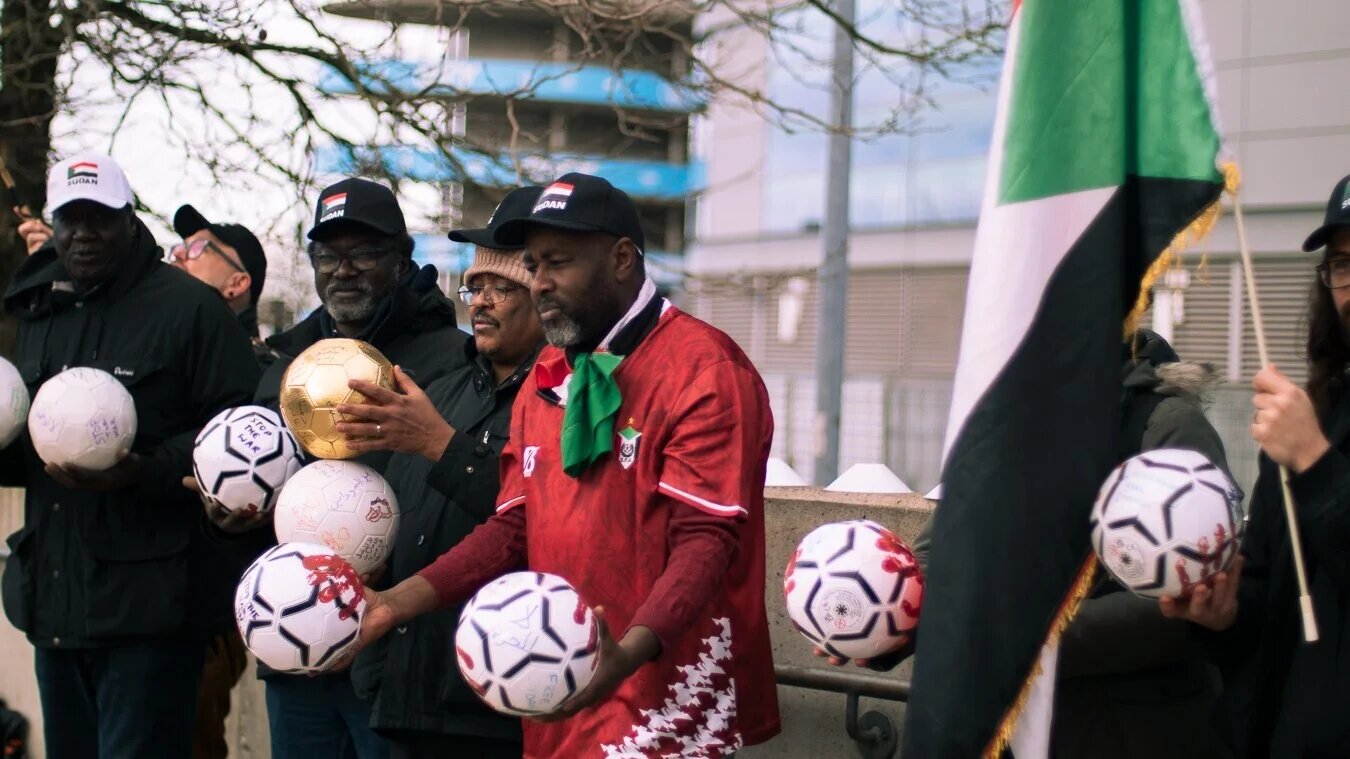 Demonstrators gather outside the Etihad Stadium in Manchester, England, on 14 January 2026 to protest human rights abuses in Sudan (supplied)