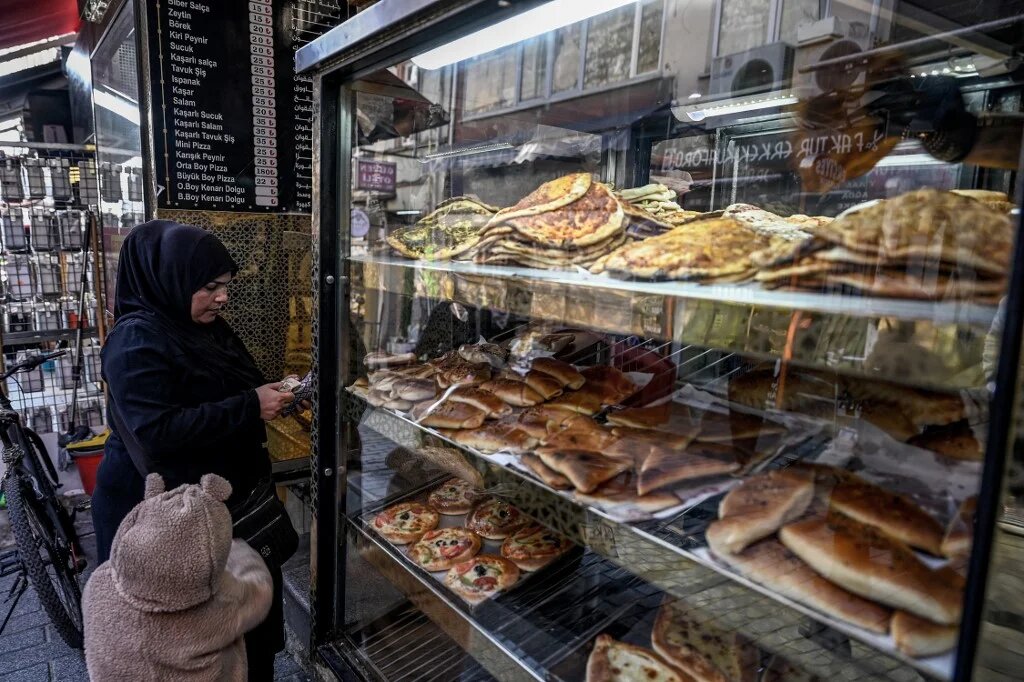 A woman buys bread in bakery at Malta bazaar at Fatih district in Istanbul, Turkey on 6 December 2024 (Ozan Kose/AFP)