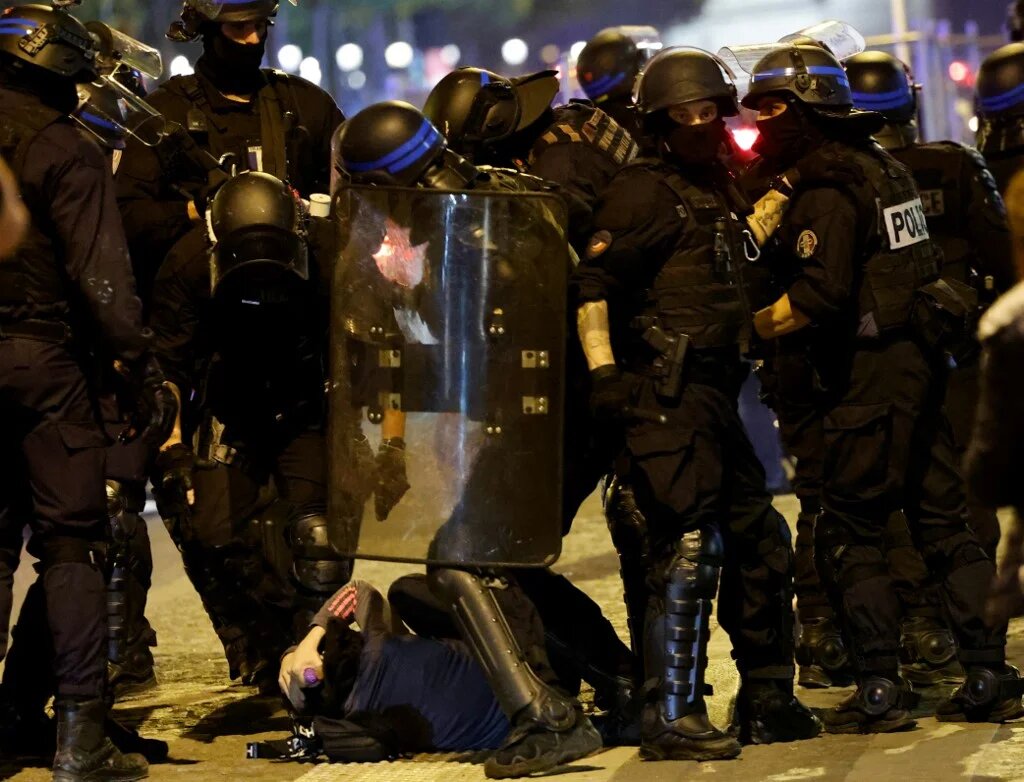 French police officers detain a demonstrator in Paris on 2 July 2023, five days after 17-year-old Nahel Merzouk was killed by police in Nanterre, a suburb of Paris (AFP)