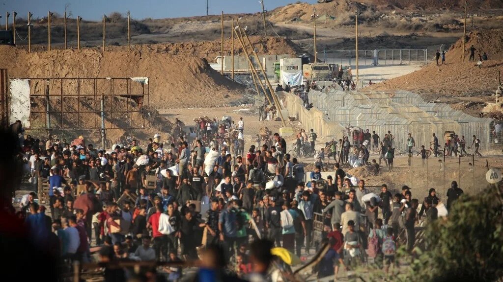 Palestinians gather at an aid distribution point set up by the privately run Gaza Humanitarian Foundation (GHF), near the Nuseirat refugee camp in the central Gaza Strip on 25 June (AFP/Eyad Baba)