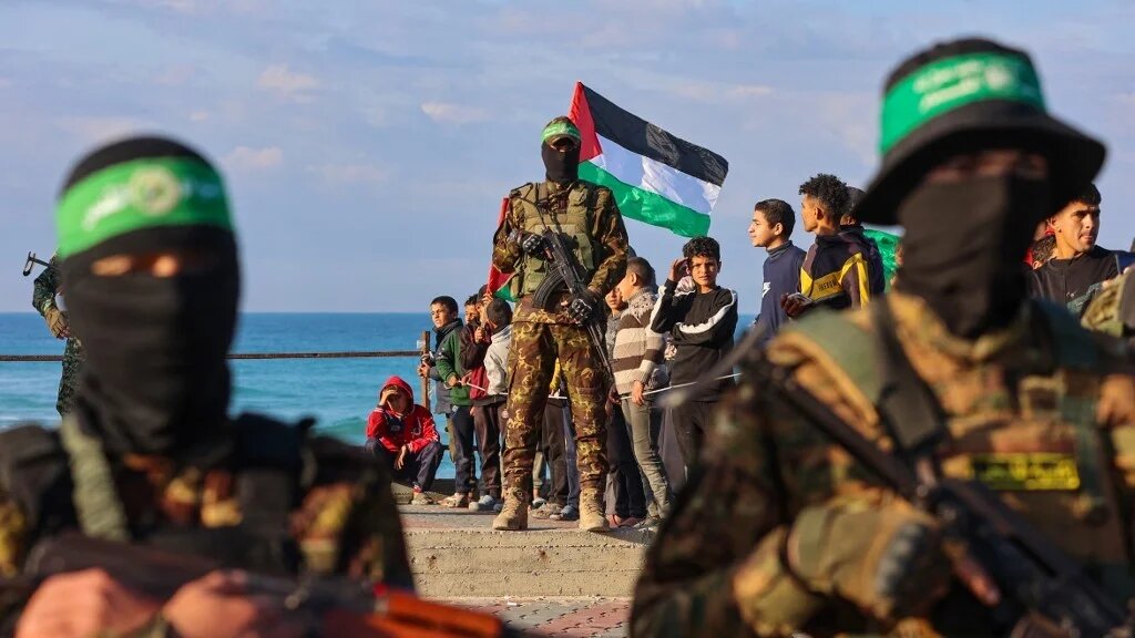 Hamas fighters secure an area before handing over an Israeli-American hostage to a Red Cross team in Gaza City on 1 February 2025, as part of the fourth hostage-prisoner exchange (Omar Al-Qattaa / AFP)
