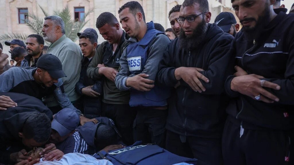 Relatives and colleagues mourn at the funeral of Palestinian journalist Hossam Shabat, an Al Jazeera Mubasher correspondent, and Mohammad Mansour, a Palestine Today correspondent, in Beit Lahia in the northern Gaza Strip, on 24 March 2025 (Bashar Taleb / AFP)