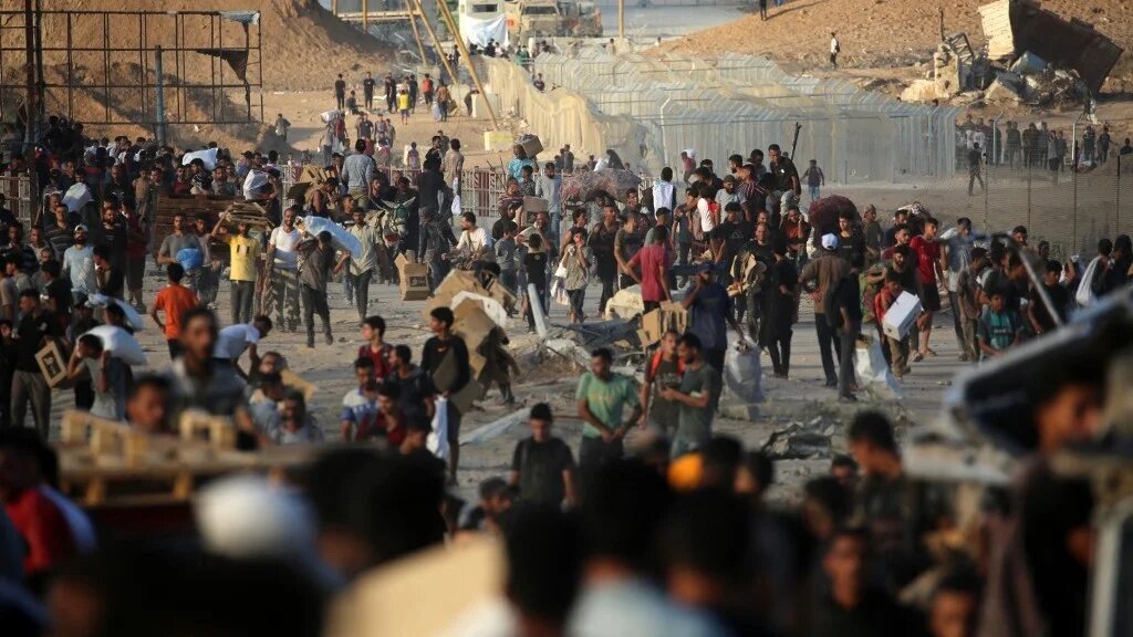 Palestinians gather at an aid distribution point set up by the Gaza Humanitarian Foundation near the Nuseirat refugee camp in the central Gaza Strip on 25 June (Eyad Baba/AFP)
