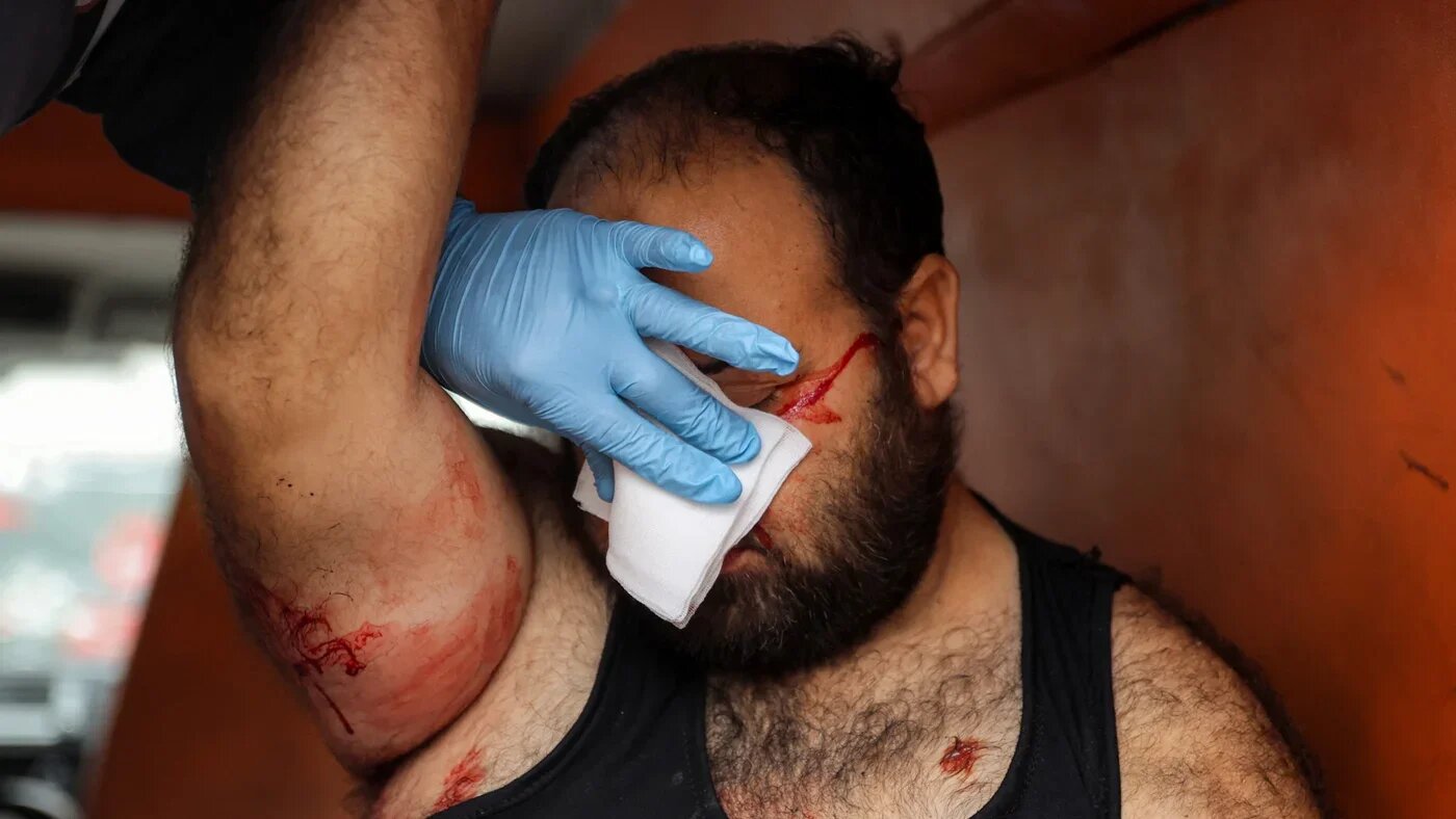 An injured man has a bandage placed on his face in an ambulance at the Ahli Arab hospital in Gaza City on 4 January 2025 (AFP/Omar al-Qattaa)