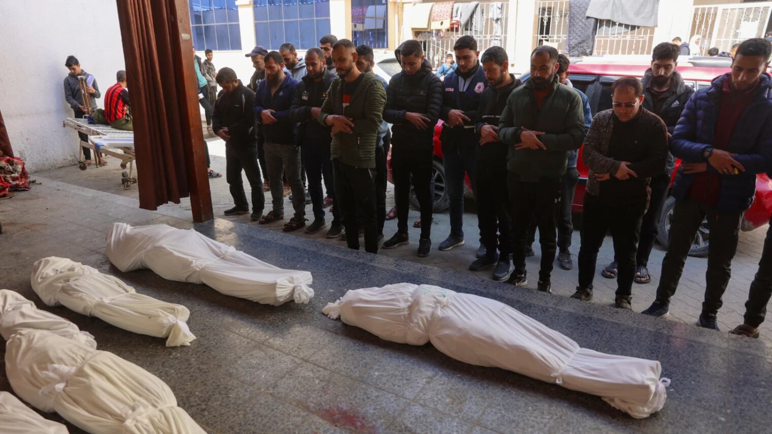 Men offer a funeral prayer in front of the bodies of people, who were killed in Israeli bombardments, at al-Ahli Arab Hospital in Gaza City on 26 March 2025 (Omar al-Qattaa/AFP)