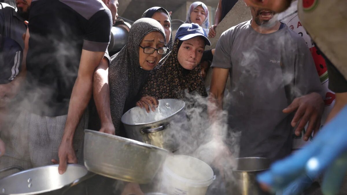 Palestinians line up to receive a hot meal at a food distribution point in Gaza City on 27 June 2025 (Bashar Taleb/AFP)