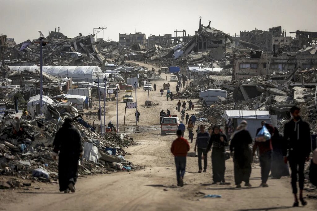 People walk past the rubble of destroyed buildings in the Jabalia camp for Palestinian refugees in the northern Gaza Strip on 8 February, 2026. (AFP/Omar al-Qattaa)