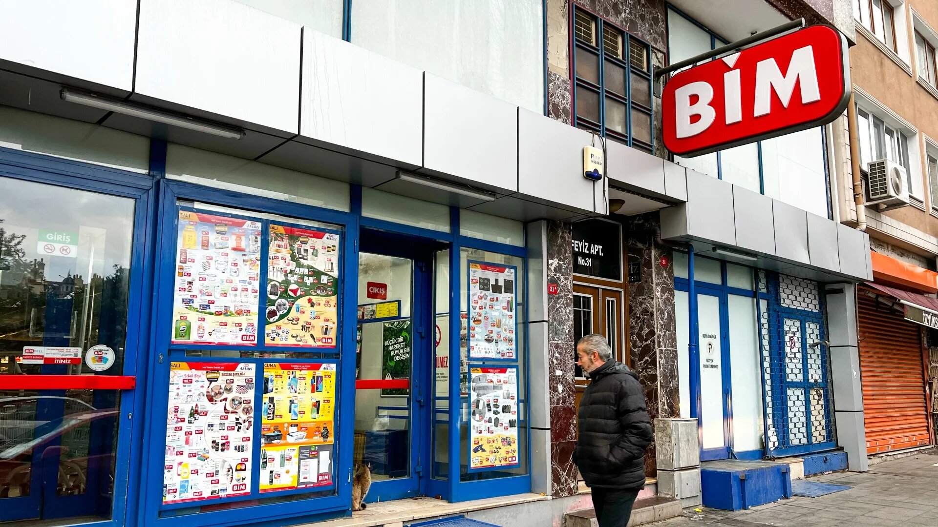 A man inspects the deals on a window of a BIM store in Istanbul (MEE/Yusuf Selman Inanc)