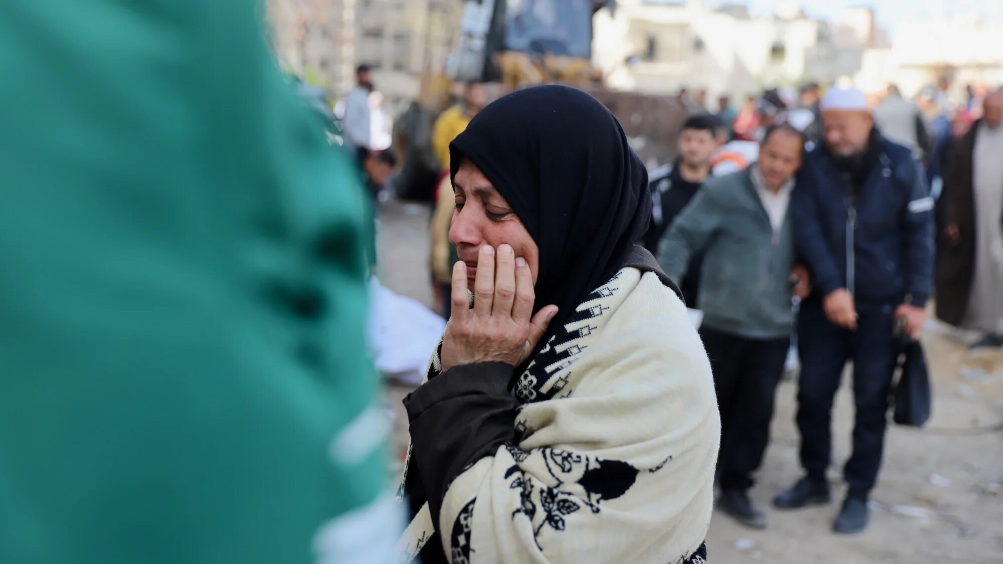 A Palestinian mother cries as a civil defence team exhumes bodies from the courtyards of al-Shifa hospital, where they were buried during Israel's siege on Gaza City on 13 March 2025 (MEE/Mohammed al-Hajjar)