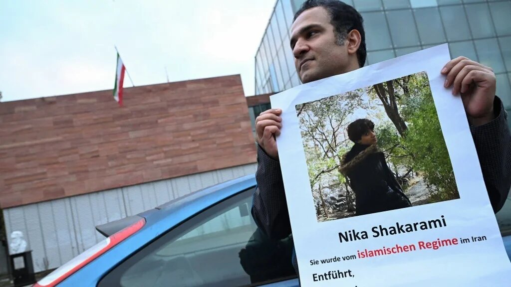 A demonstrator holds a photo of Iranian Nika Shakarami, who was believed to have been killed by Iranian security forces, during a rally against Iranian executions outside the Iranian consulate in Frankfurt, Germany, 31 October 2024 (Kirill Kudryavtsev / AFP)