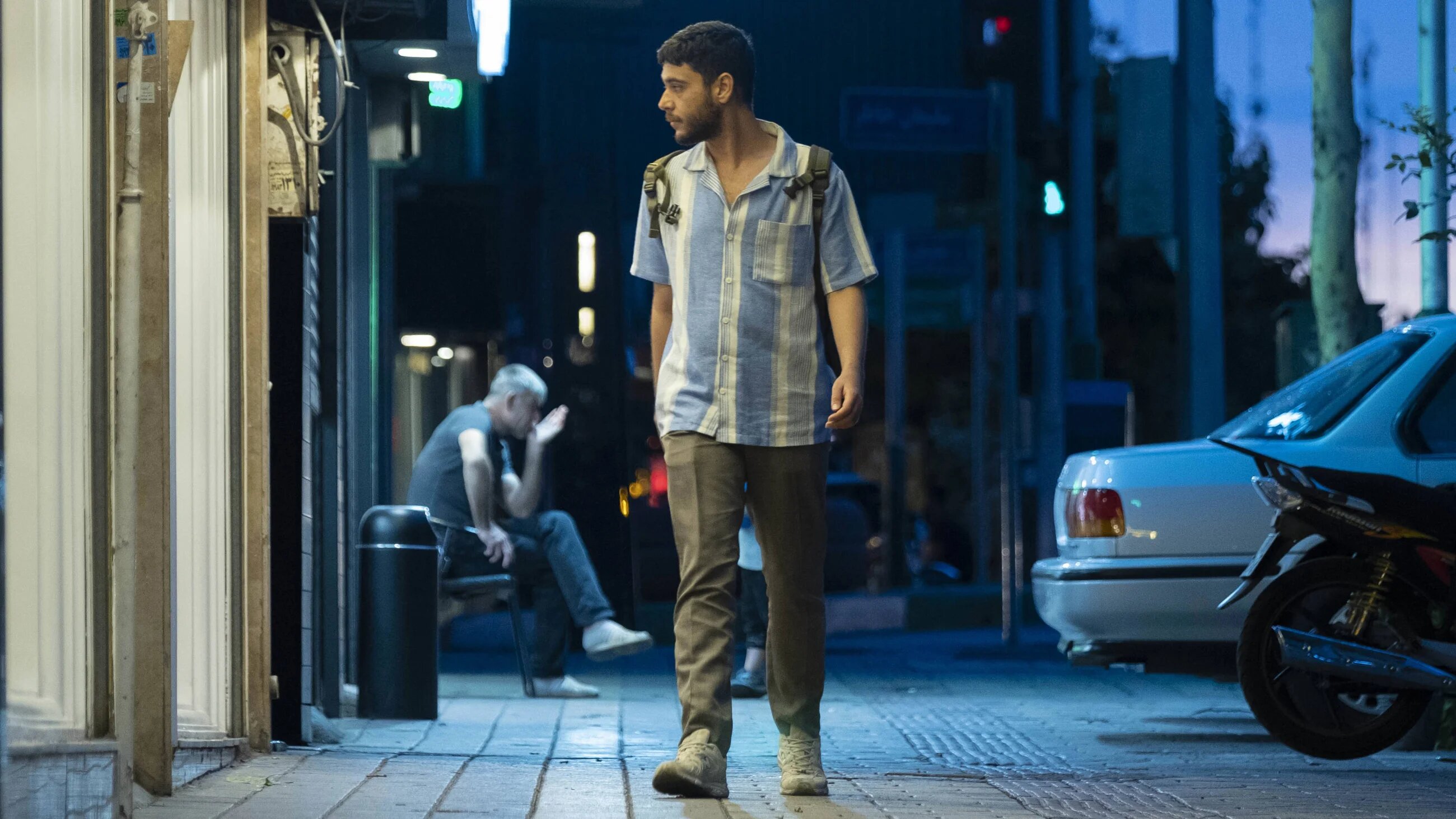 A young Iranian man walks along a street in downtown Tehran at sunset on 8 June 2023 (Reuters)