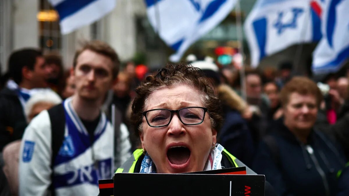 Protesters hold placards and wave Israeli flags at a "Rape is NOT resistance" demonstration outside the BBC headquarters, London on 4 February 2024 (Henry Nicholls/AFP)