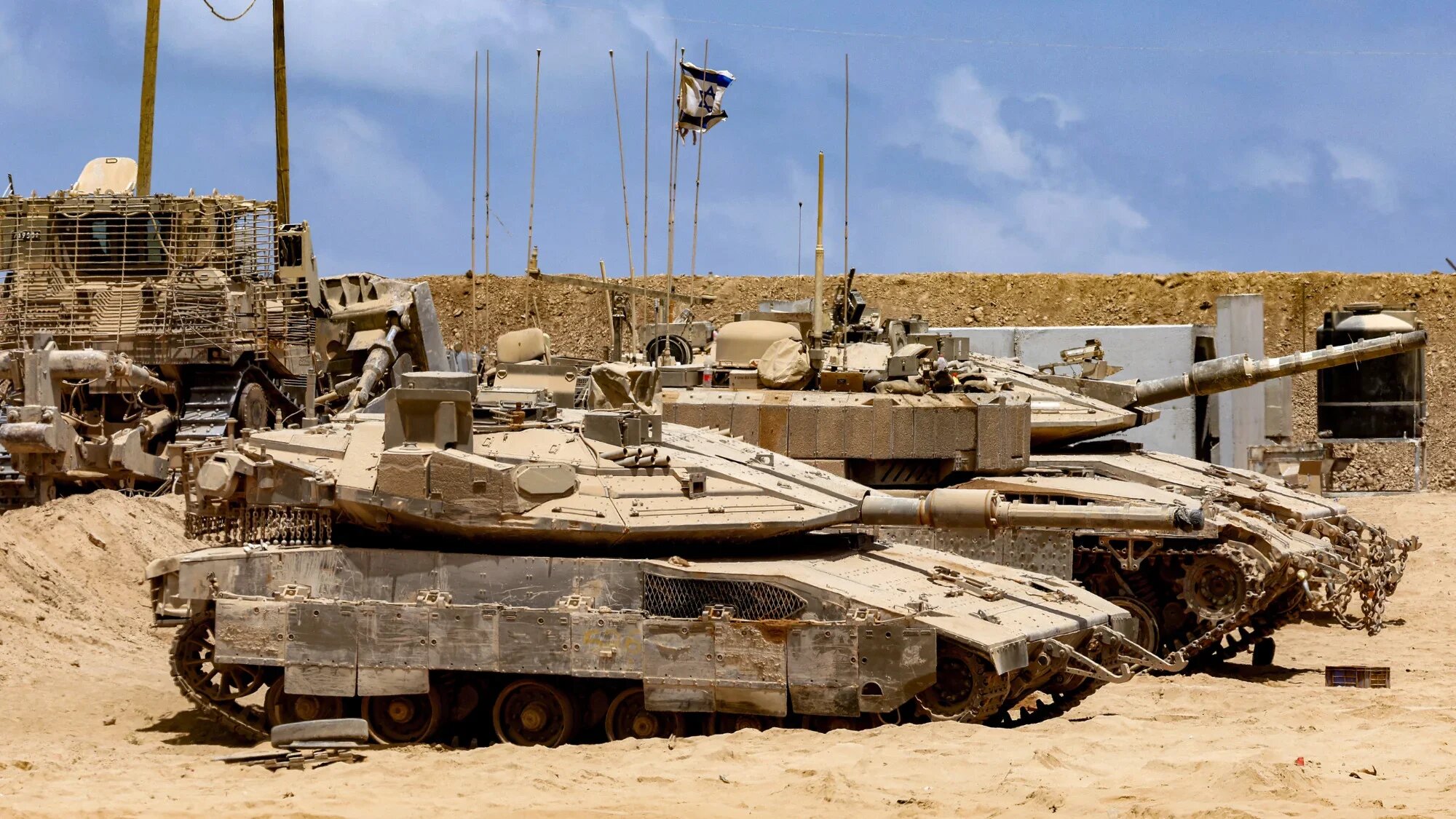 Israeli army battle tanks are positioned near the Gaza Strip boundary in southern Israel on 5 August 2025 (AFP/Jack Guez)