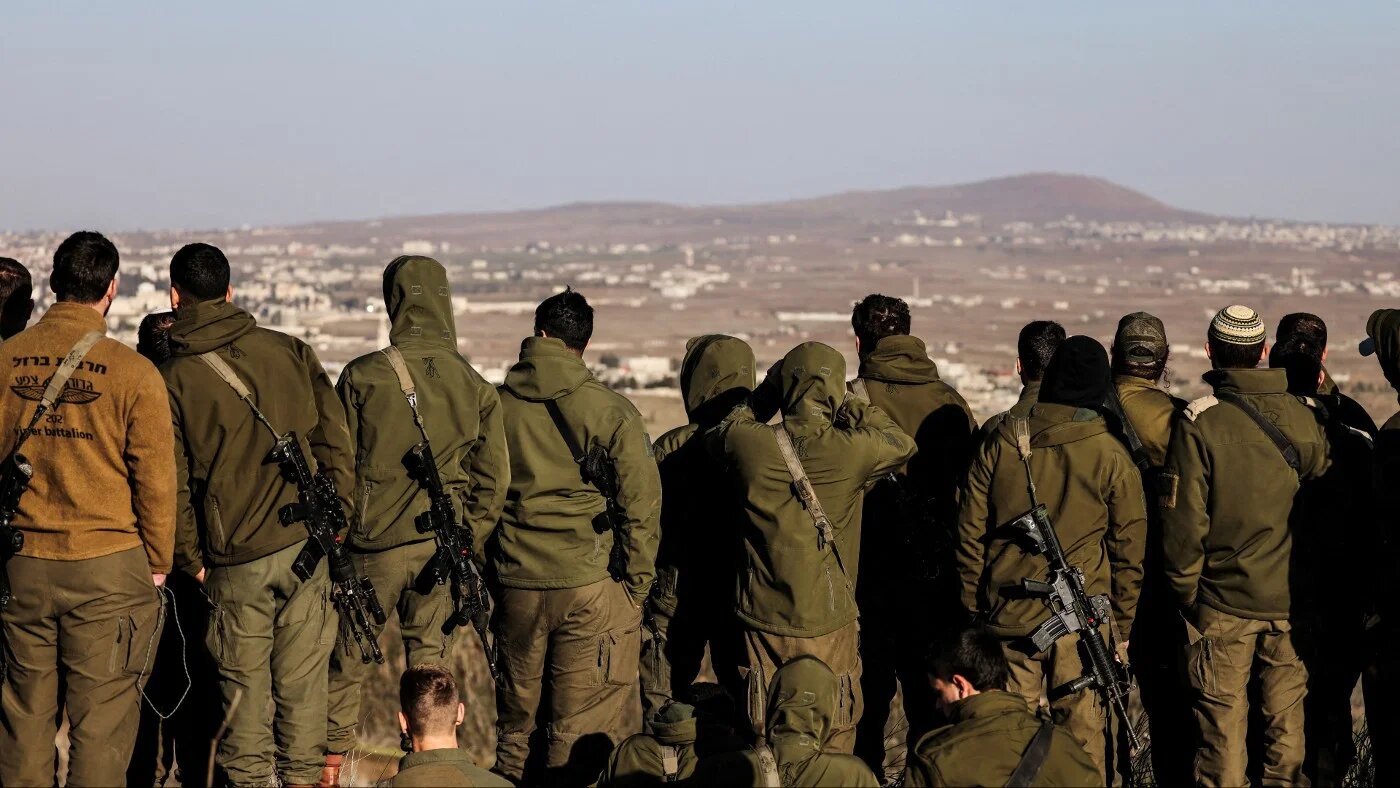 Israeli soldiers look into Syria, after the ousting of Bashar al-Assad, in Ein Zivan in the Israeli-occupied Golan Heights, 25 December 2024 (Jamal Awad/Reuters)