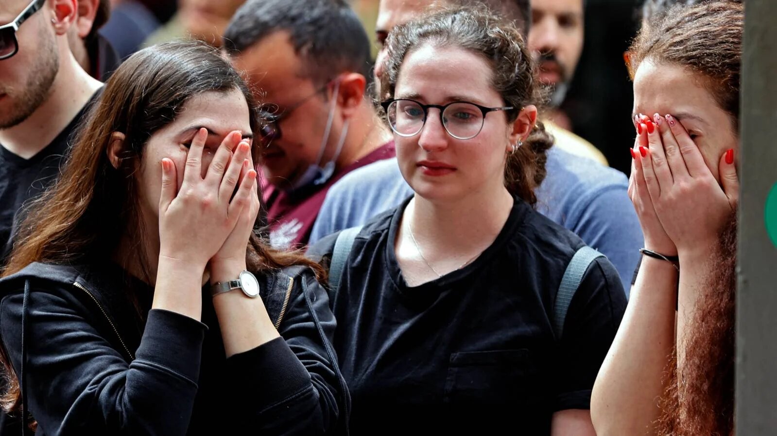 Israelis react at the site of a shooting the previous night at Dizengoff Street in the centre of Israel's Mediterranean coastal city of Tel Aviv, 8 April 2022. (AFP)