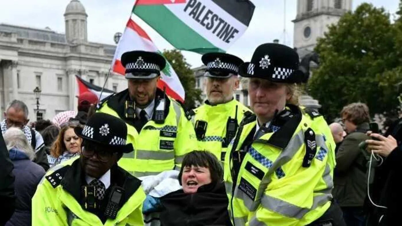A protester is taken away by police officers at a 'Lift The Ban' demonstration in support of Palestine Action in central London, on 4 October (AFP)