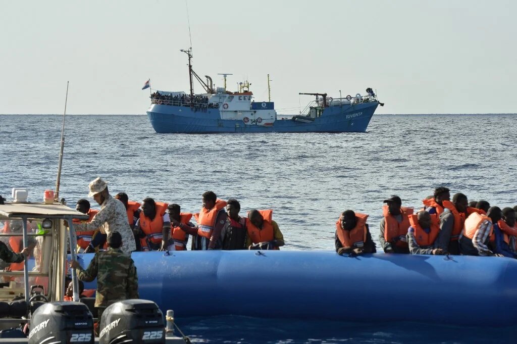 Migrants on a rubber boat are helped by a Libyan coast guard patrol during a rescue operation with a ship run by a German NGO, in November 2016 (Andreas Solaro/AFP)