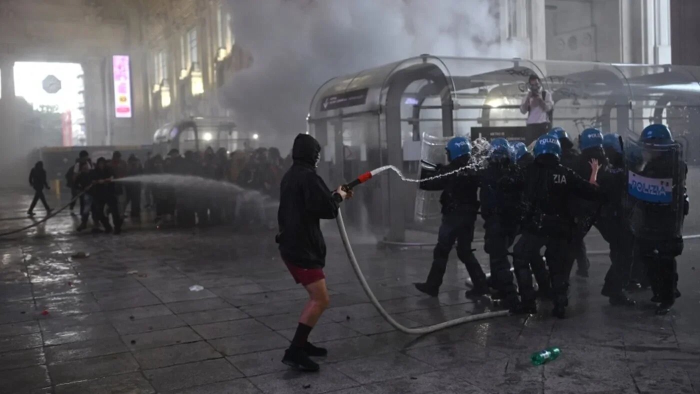 Protesters clash with anti-riot police at Milano Centrale train station on the sidelines of a nationwide strike in Milan, northwestern Italy on 22 September 2025 (Piero Cruciatti/AFP)