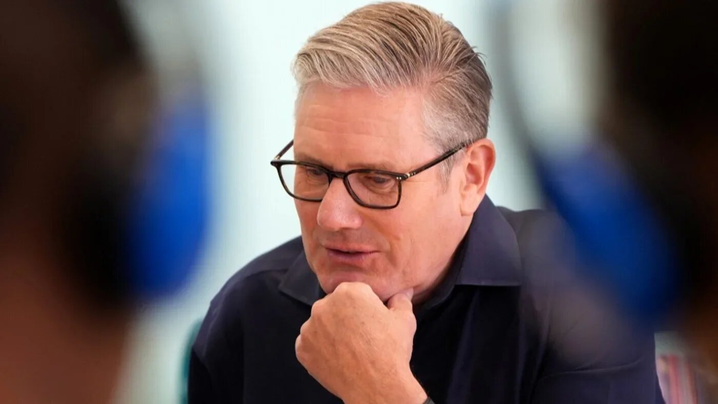 Britain's Prime Minister Keir Starmer talks to children and staff during a music lesson at a library in Milton Keynes on 6 August (AFP)
