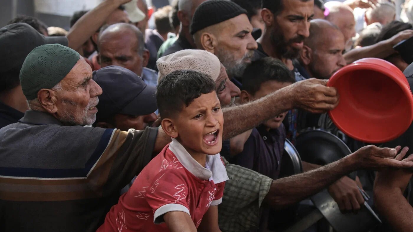 Palestinians gather to receive food from a charity kitchen in Nuseirat refugee camp, in the central Gaza Strip, on 15 October 2025 (Eyad Baba/AFP)