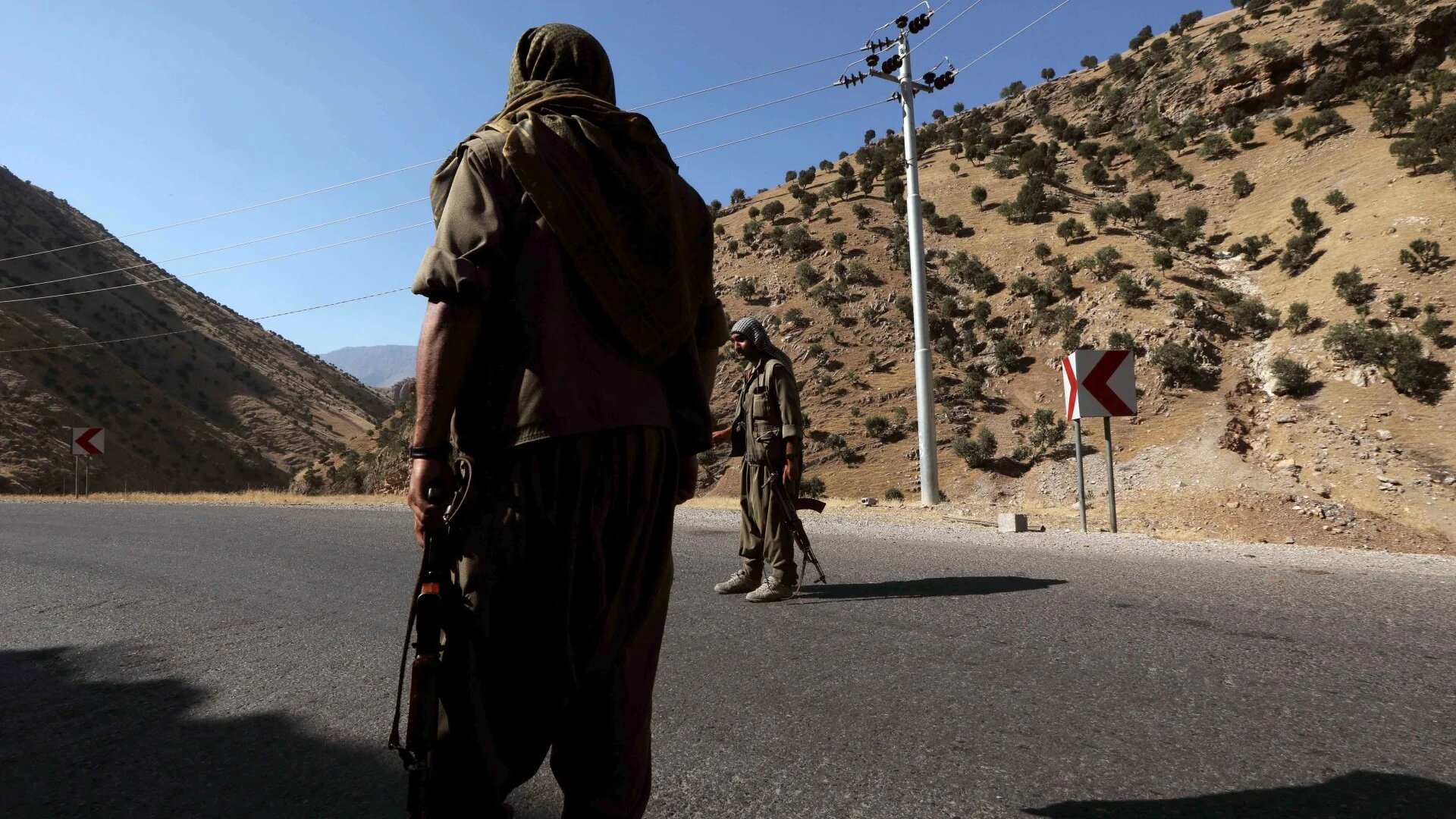 A member of the PKK carries an automatic rifle on a road in the Qandil Mountains in northern Iraq, 22 June, 2018 (AFP/Safin Hamid)